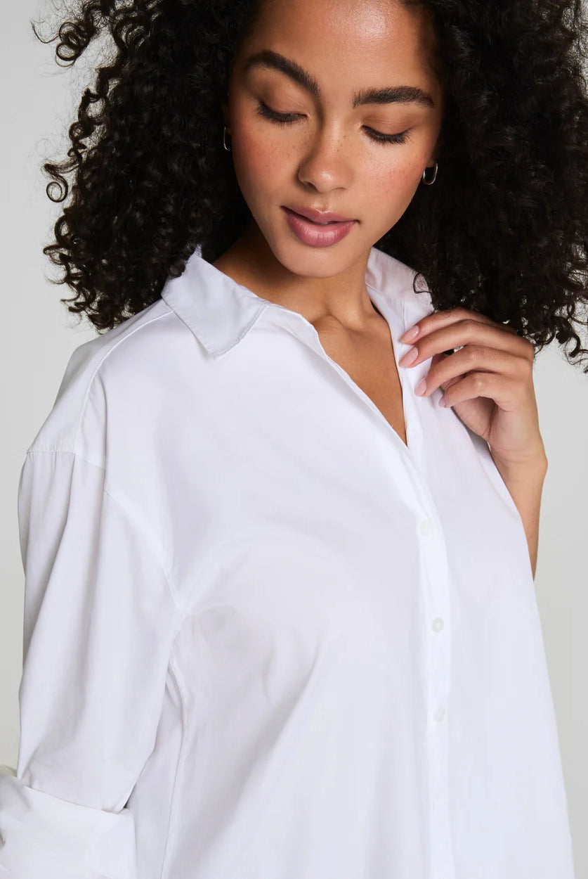 Woman wearing a white shirt against a plain background