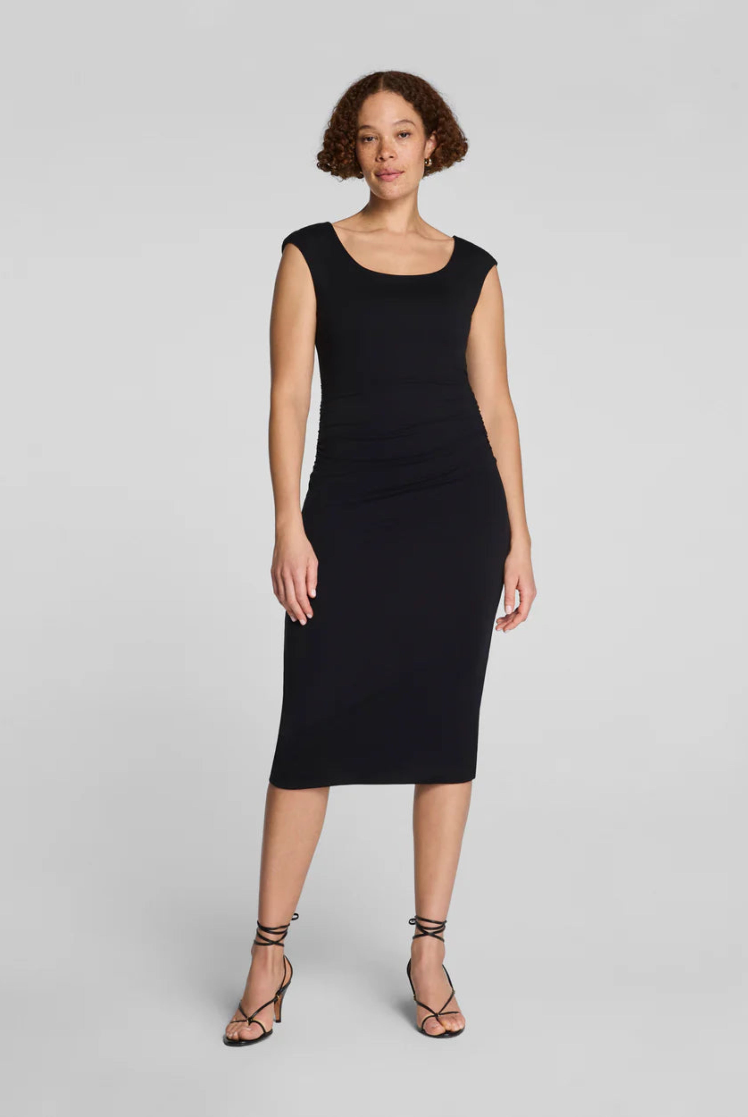 Woman wearing a black dress on a gray background