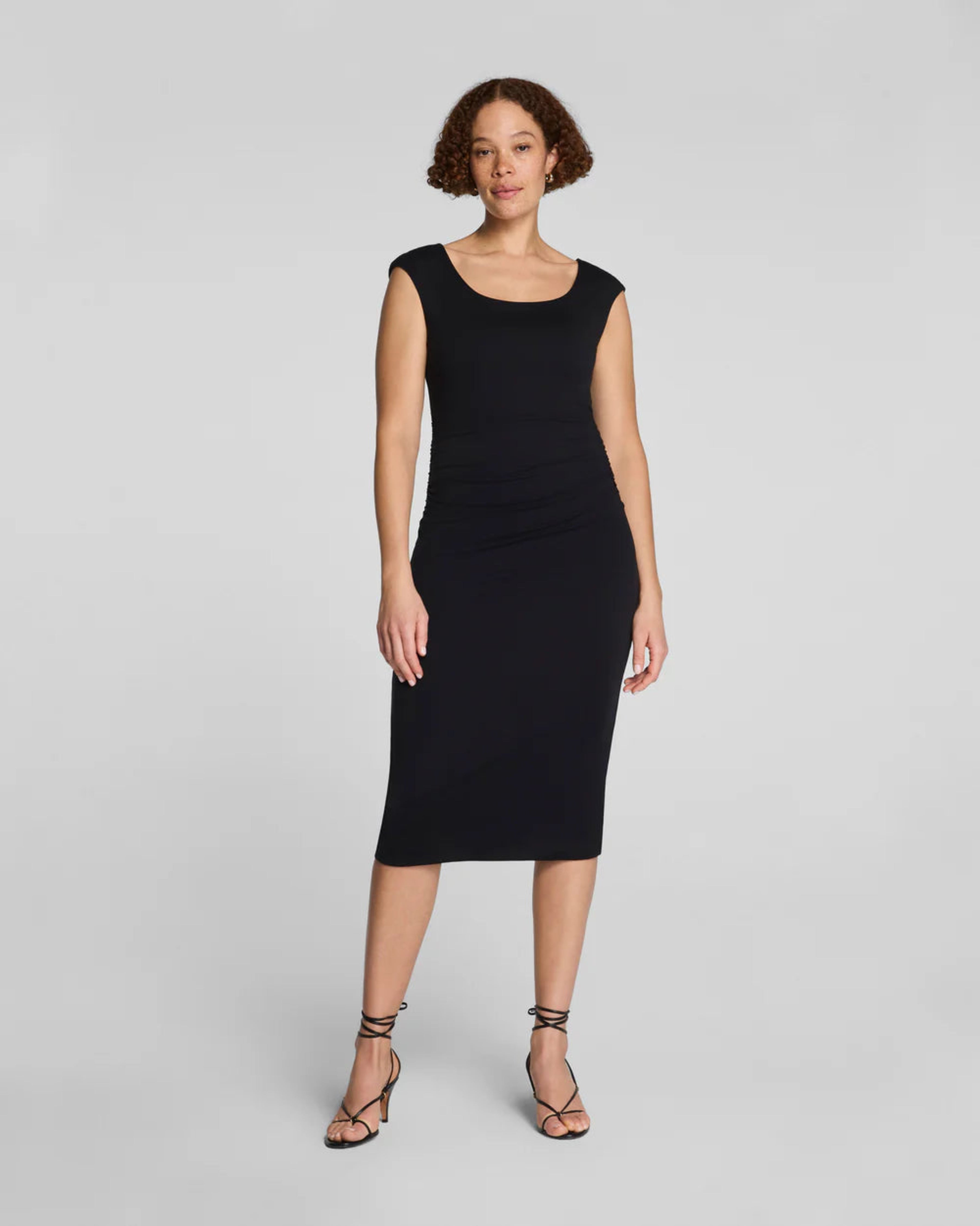 Woman wearing a black dress on a gray background