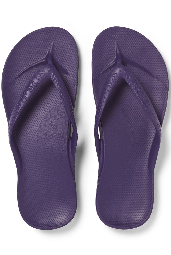 Pair of purple flip-flops on a white background