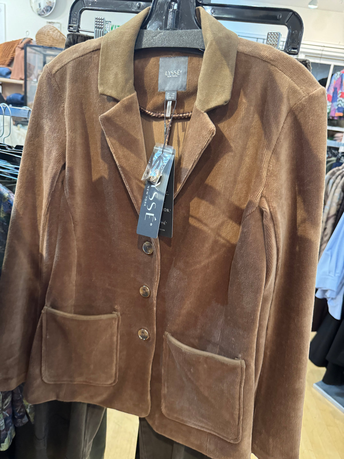Tan soft blazer hanging in a store