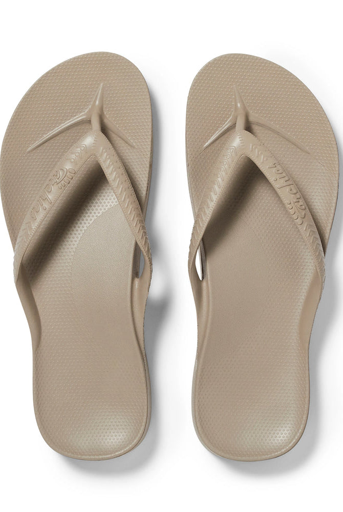 Pair of beige flip-flops on a white background