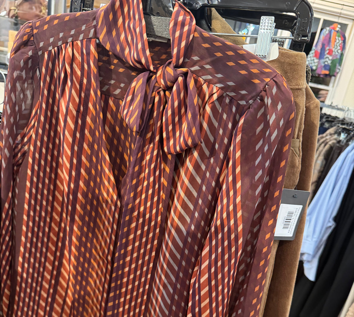 Tie blouse in cranberry color in clothing store