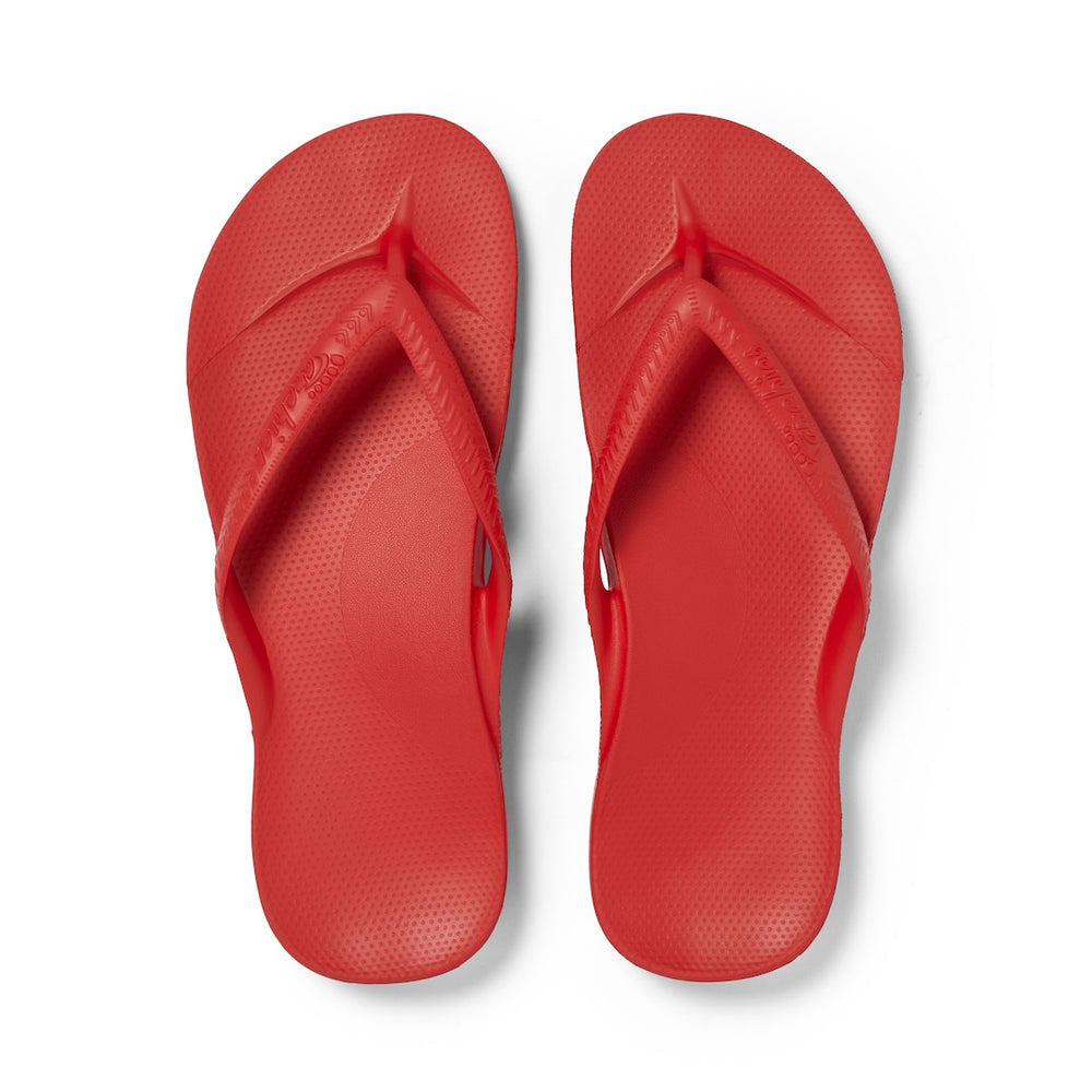Pair of red flip-flops on a white background