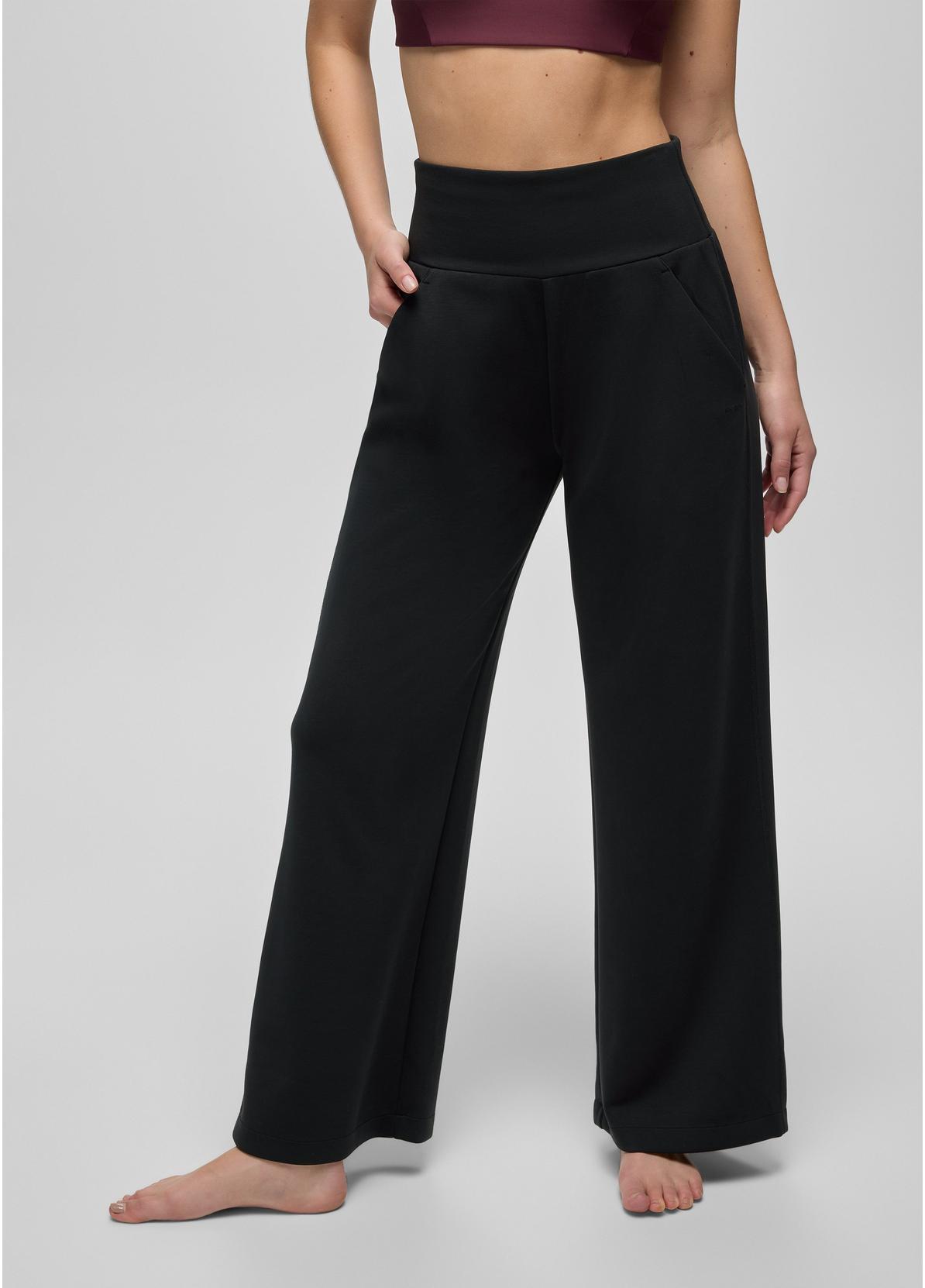Person wearing black wide-leg pants on a plain background