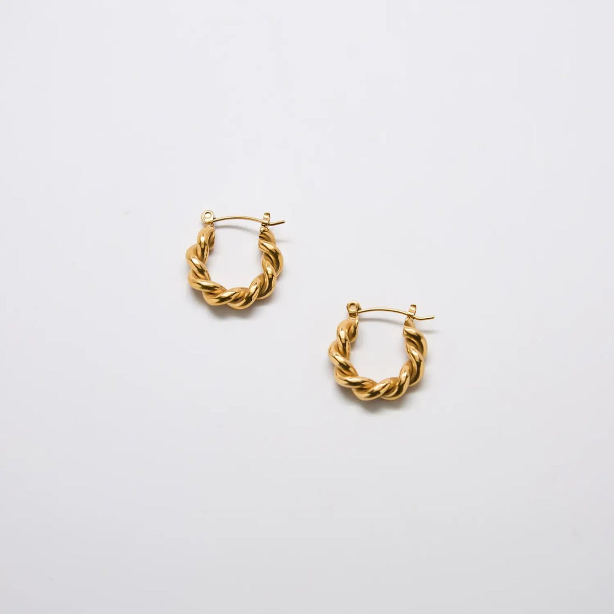 Pair of gold-tone oval twist hoop earrings with a textured twisted design