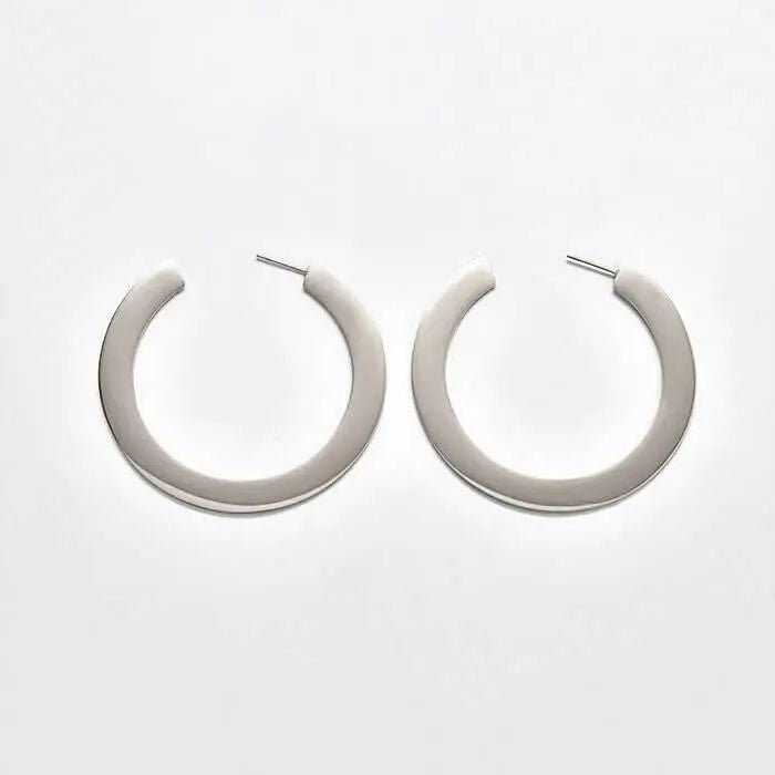 Pair of medium silver-tone flat hoop earrings on a light background