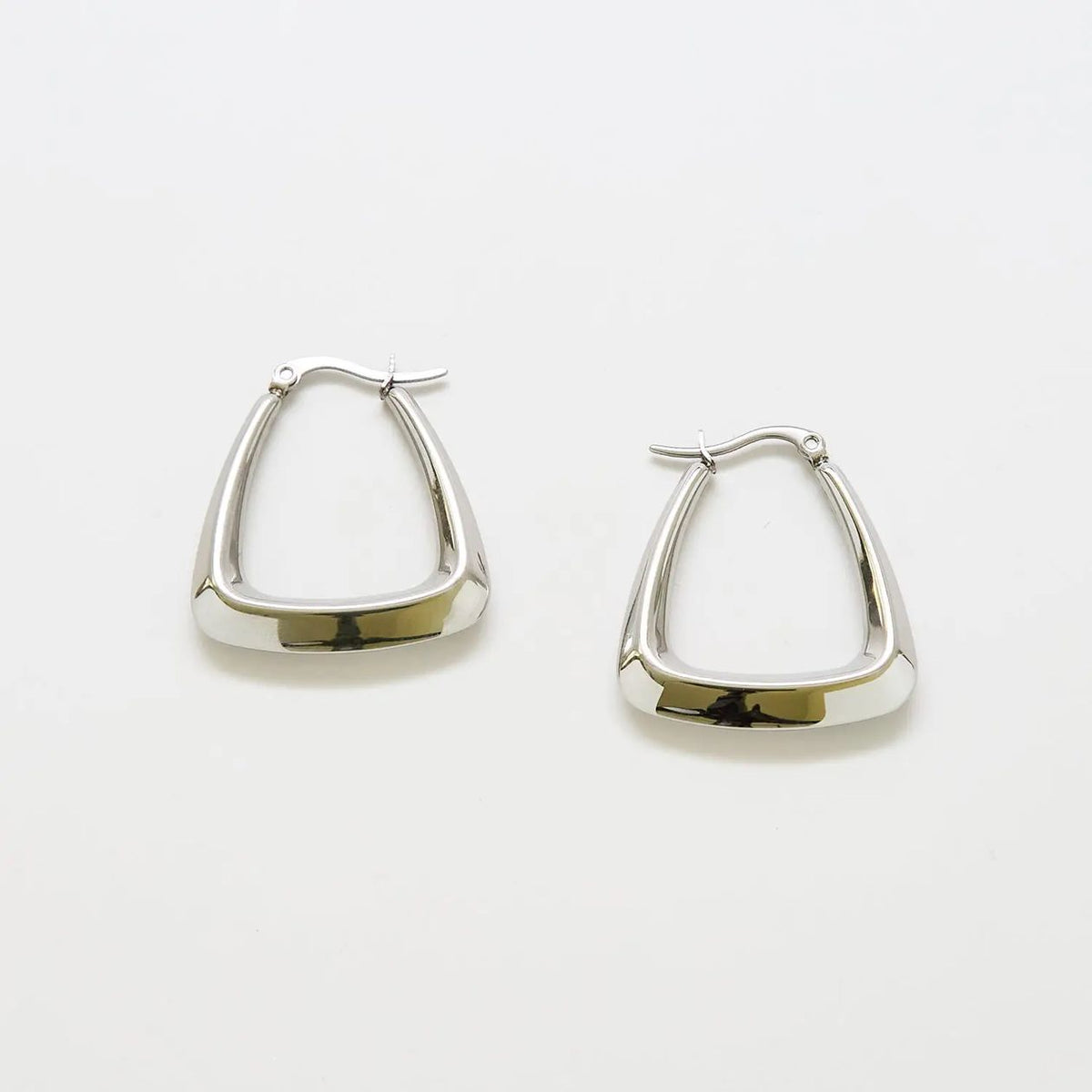 Pair of silver-tone triangle hoop earrings on a light background
