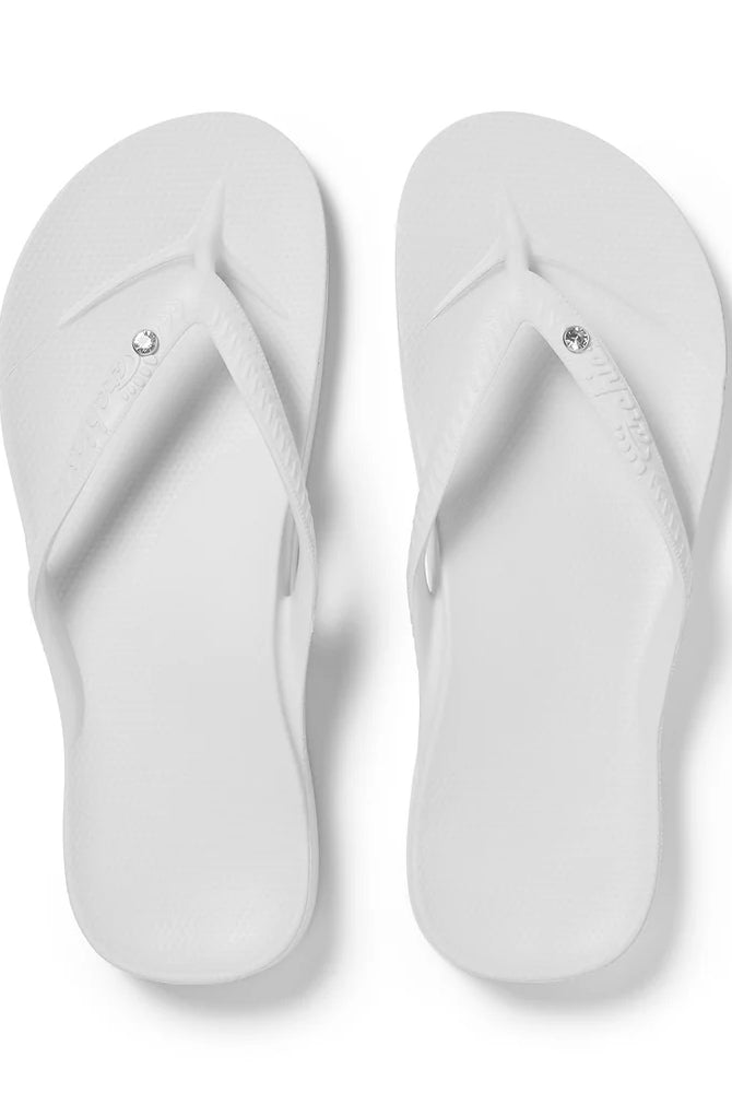 White flip-flops with crystal embellishments on a white background