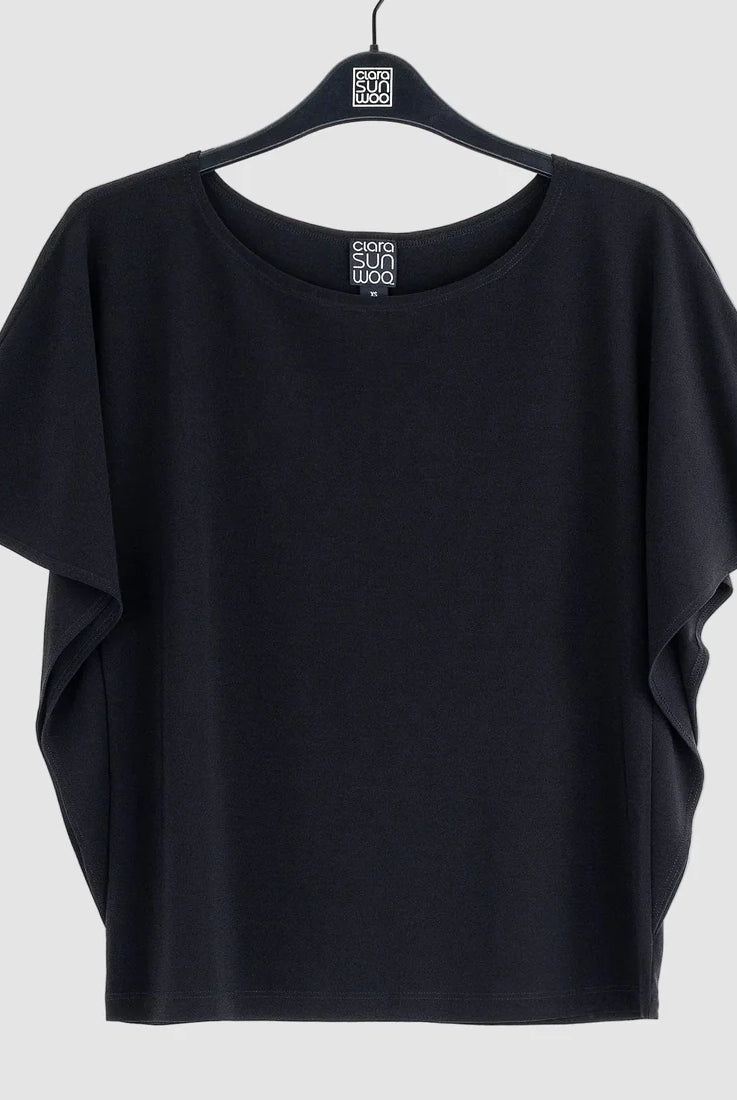 Black t-shirt on a hanger against a white background