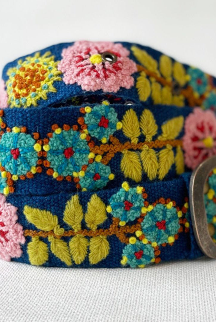 Colorful floral embroidered belt with a metal buckle on a white background
