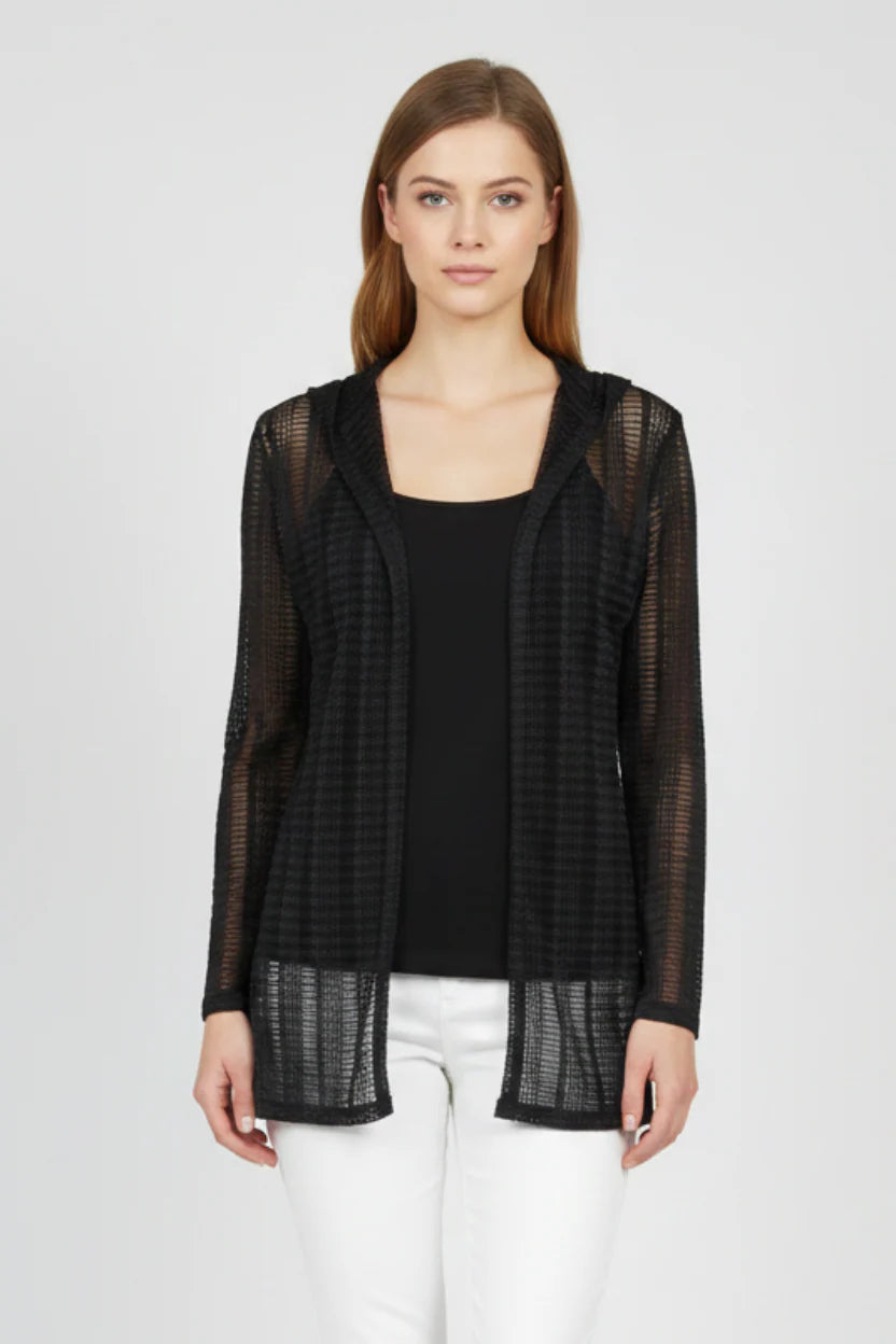 Woman wearing a black sheer jacket over a black top and white pants on a white background