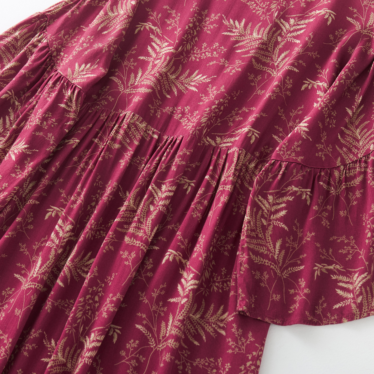 Close-up of the gold botanical print on red satin