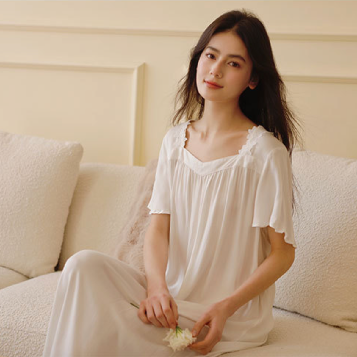 Woman seated wearing the white lace trim viscose nightdress