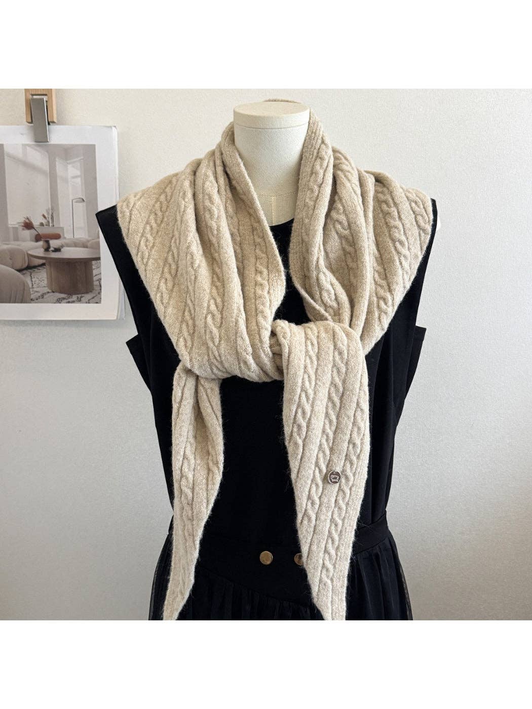 Ivory cable knit triangle scarf worn over a black top