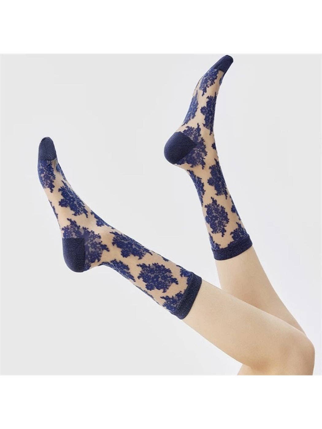 Blue flocked floral sheer socks on foot
