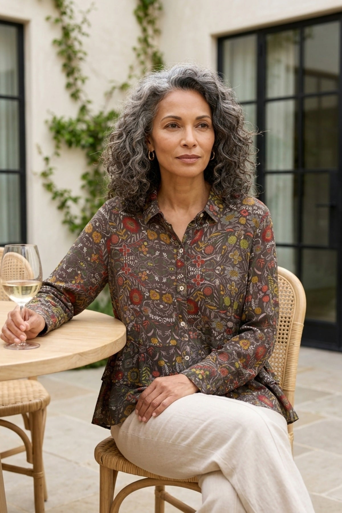 Habitat Rayon Crepe Garden Flounce Shirt in olive floral, seated on a patio
