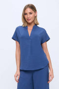 blue top on a woman with a white background