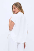 Woman wearing a white blouse and pants on a white background