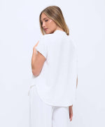 Woman wearing a white blouse and pants on a white background