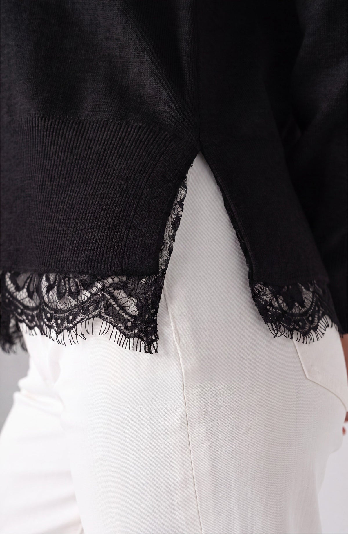 Close-up of the lace trim detail on the black Liverpool V-neck sweater