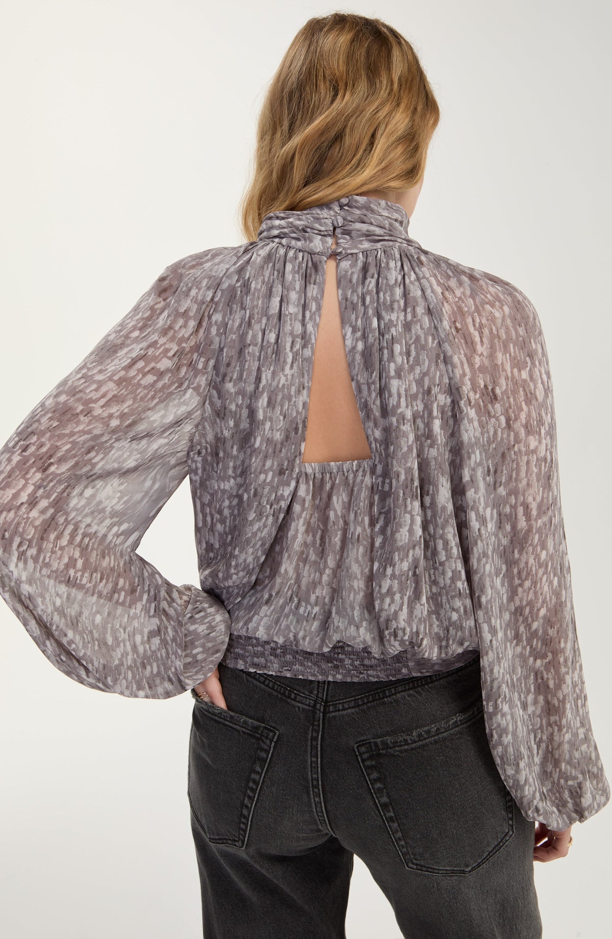 Back view of the Liverpool shirred mock neck top showing the keyhole button closure