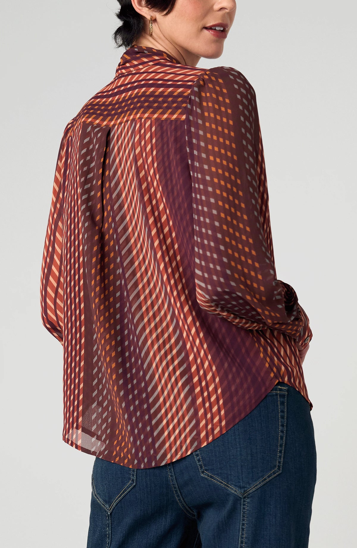 Back view of the Long Sleeve Woven Blouse with Neck Tie in Burgundy Rust geometric stripe, styled with denim
