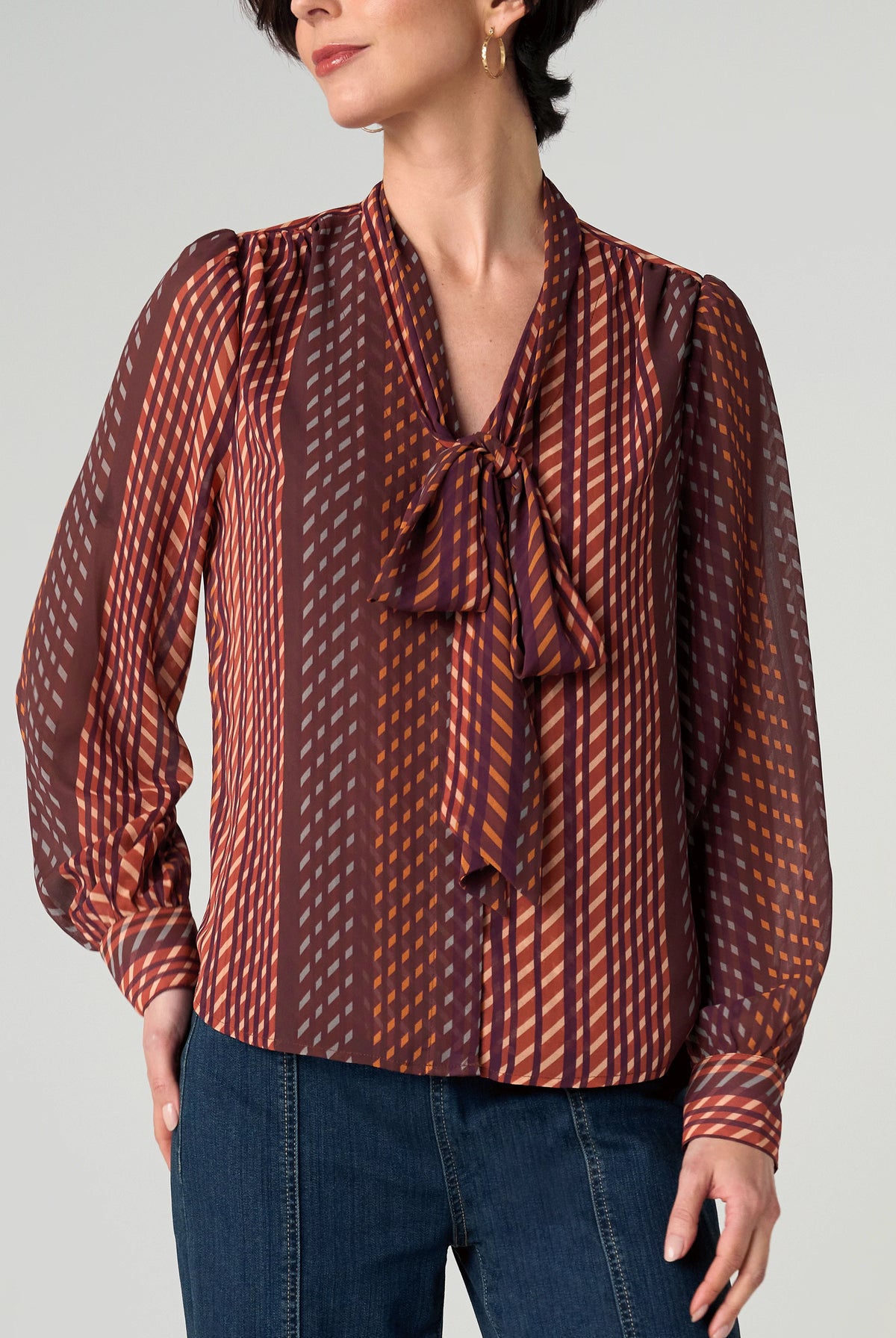 Front view of the Long Sleeve Woven Blouse with Neck Tie in Burgundy Rust geometric stripe, tied in a bow at the neck