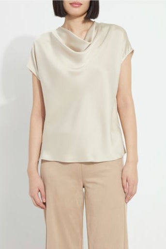 Model wearing the Lysse Yasmin Drape Neck Sleeveless Blouse in travertine cream satin with tan trousers