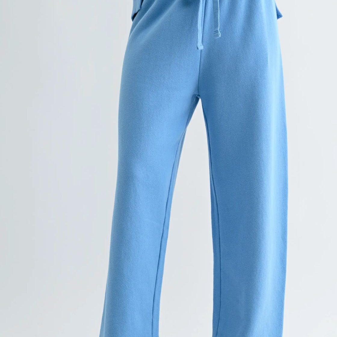 woman wearing light blue wide leg pant with white sneakers