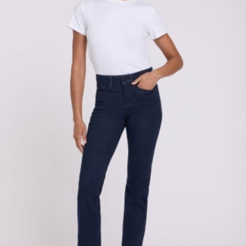 A woman modeling NYDJ Marilyn Straight jeans in Rinse dark blue wash, paired with a white t-shirt, against a plain light studio background.