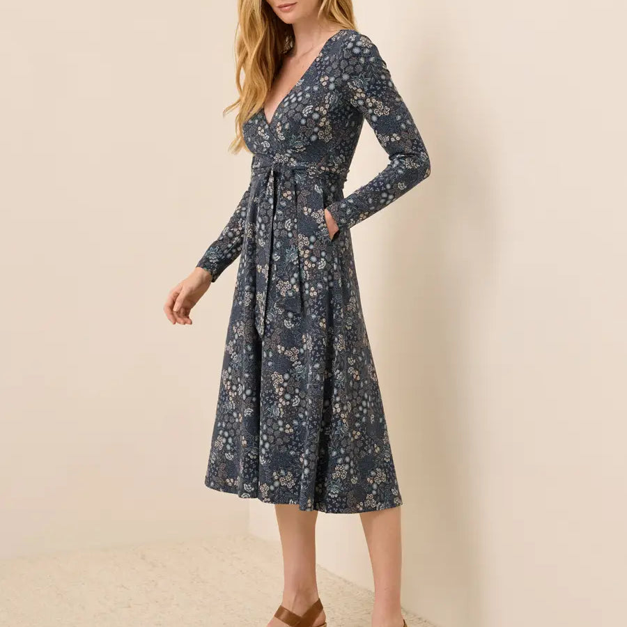 PACT Fit and Flare Wrap Dress in Mountain Meadow Midnight Blue navy floral print, long-sleeve wrap midi with tie waist and pocket, side view