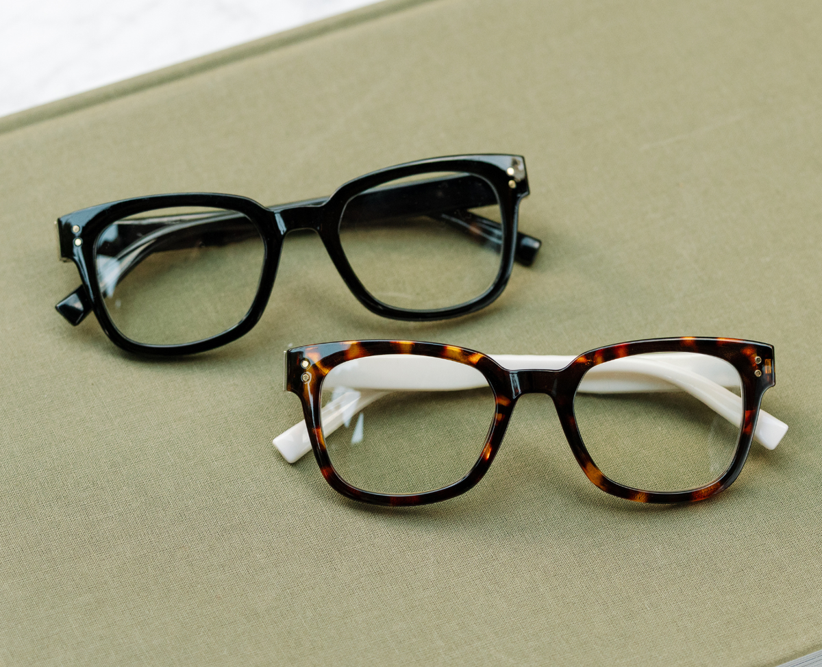 Peepers Aubrey blue light reading glasses in black, styled flat lay