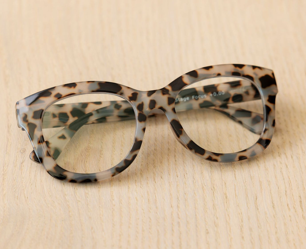 Peepers Center Stage reading glasses in Gray Tortoise, styled flat lay