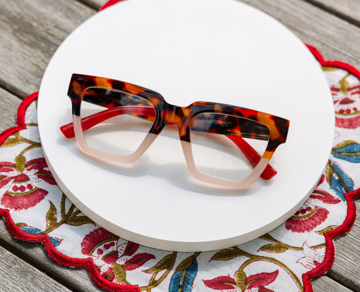 Peepers Take A Bow reading glasses in tortoise and blush, styled flat lay