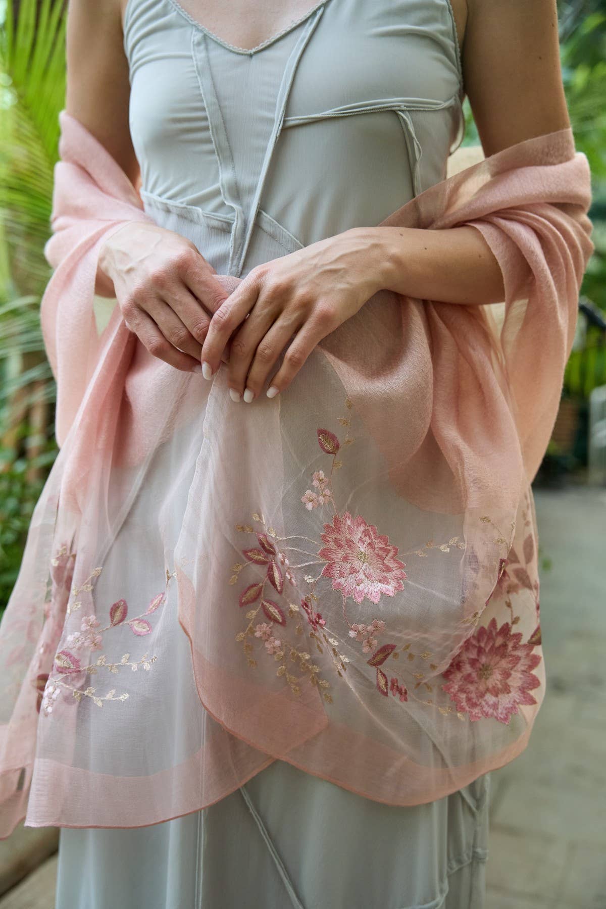 Blush pink floral embroidered scarf styled as a wrap