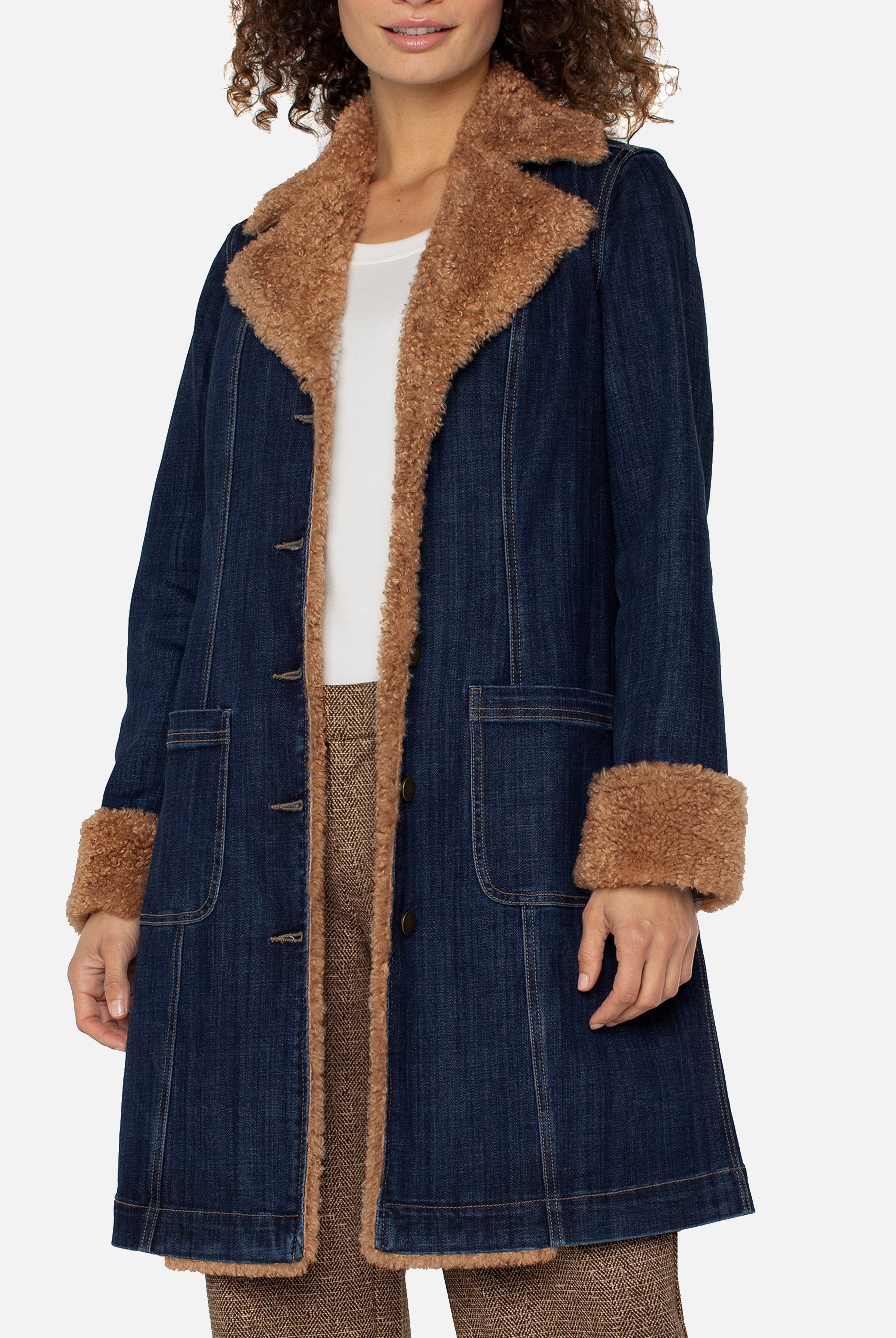 Woman wearing a denim coat with brown fur trim on a white background