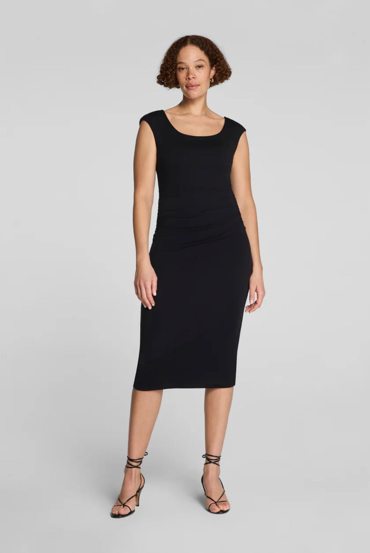 Spanx Spanxsmooth Jersey Ruched Midi Dress in black, scoop neck, cap sleeves, fitted bodycon midi silhouette, front view on model