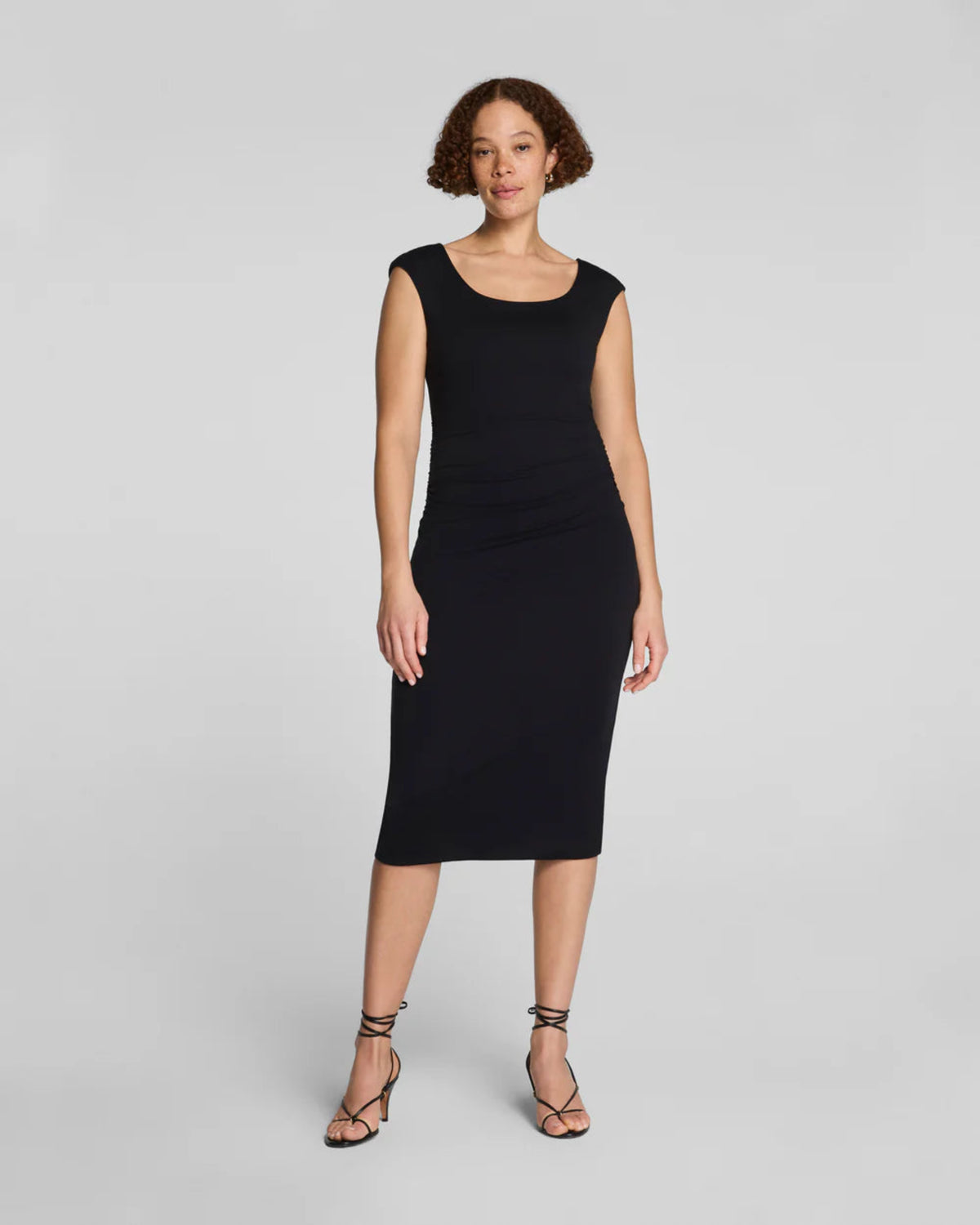 Spanx Spanxsmooth Jersey Ruched Midi Dress in black, scoop neck, cap sleeves, fitted bodycon midi silhouette, front view on model