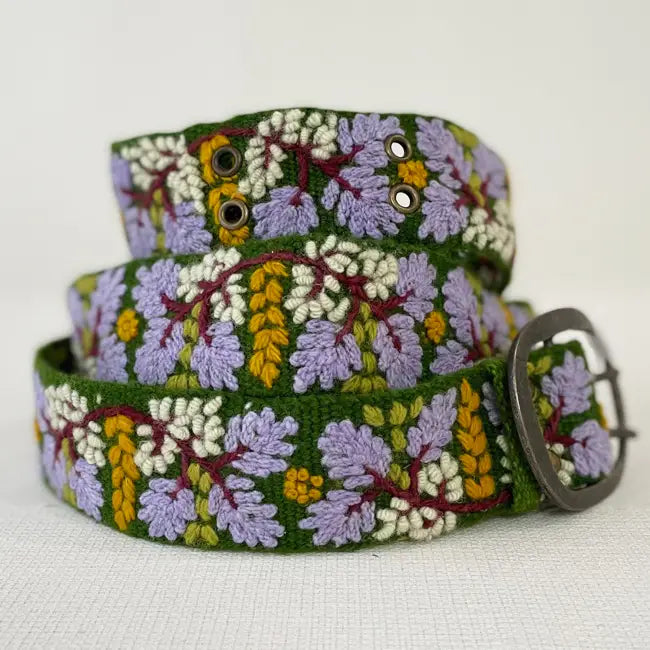 Floral patterned belt with a metal buckle on a white background