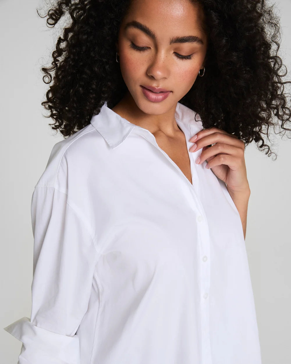 Woman wearing a white shirt against a plain background
