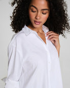 Woman wearing a white shirt against a plain background