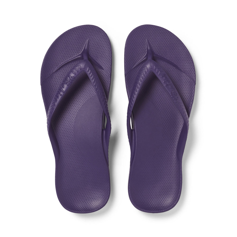 Pair of purple flip-flops on a white background