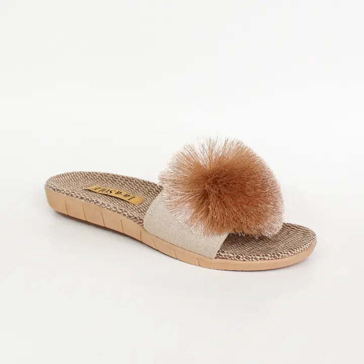 Beige sandal with a brown fuzzy pom-pom on a white background