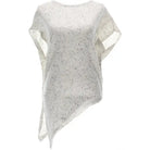 A loose-fitting, asymmetrical knit poncho top in a light cream or off-white color with small black speckles, shown against a plain white background.