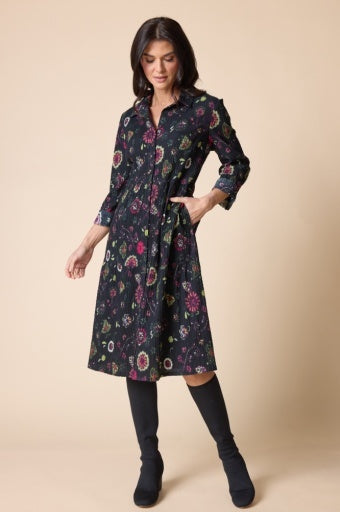 Woman wearing a floral dress with long sleeves on a beige background