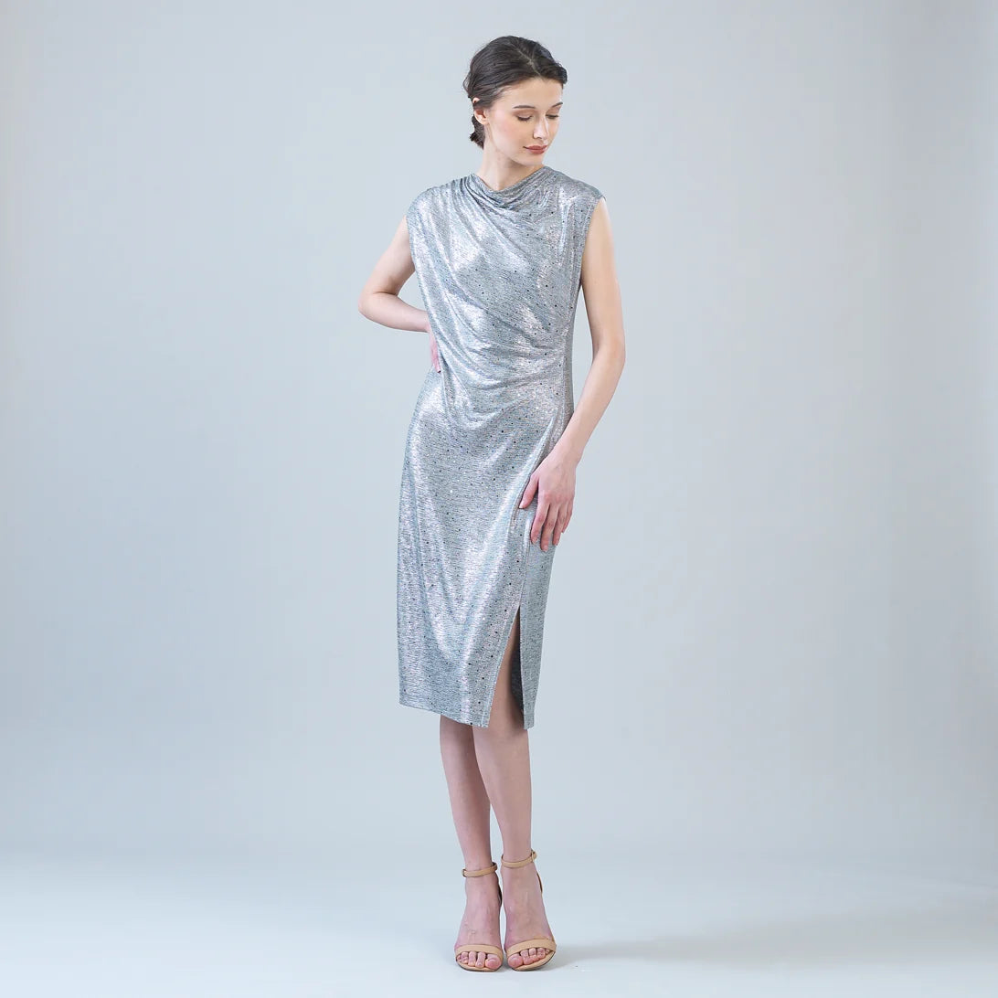 Woman wearing a silver sleeveless dress on a plain background