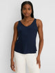 Lace Trim Day Gloss Tank in Dark Indigo, a woman wearing the navy lace-trim tank top with white pants against a plain background