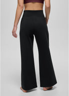 Person wearing black wide-leg pants on a plain background