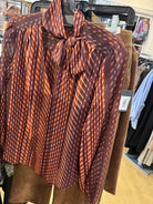 Tie blouse in cranberry color in clothing store
